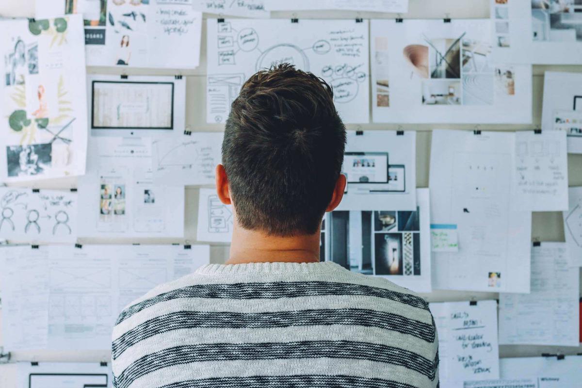 man sitting before huge to do board