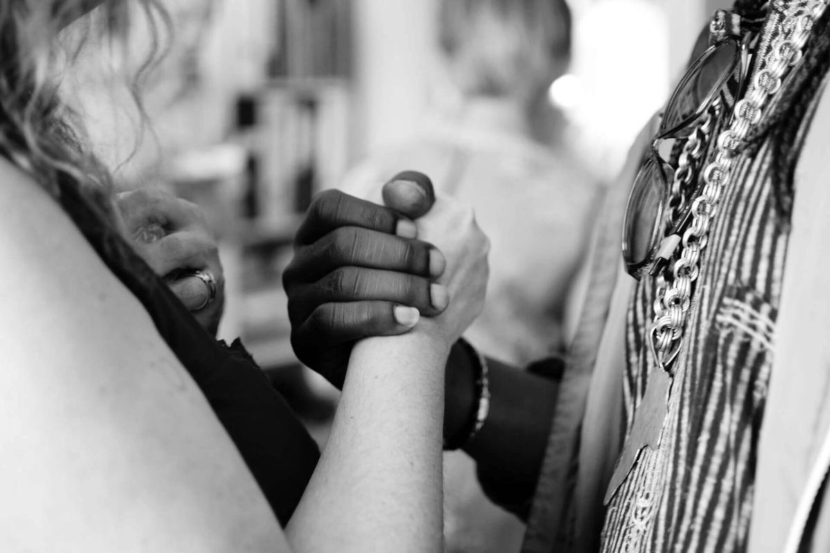 Two people of different ethnic backgrounds joining hands to represent the concept of diversity in hiring